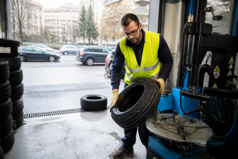 Dépanneur en train de monter un pneu au centre auto Leclerc à Paris