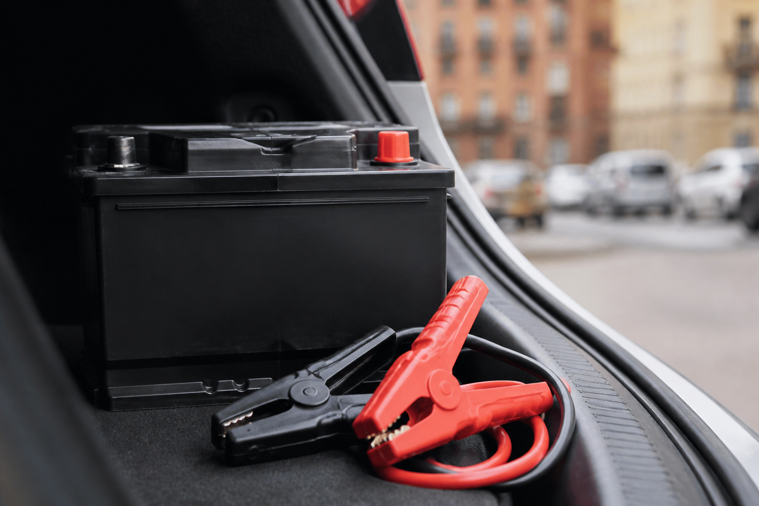Batterie de voiture avec câbles de démarrage dans un coffre