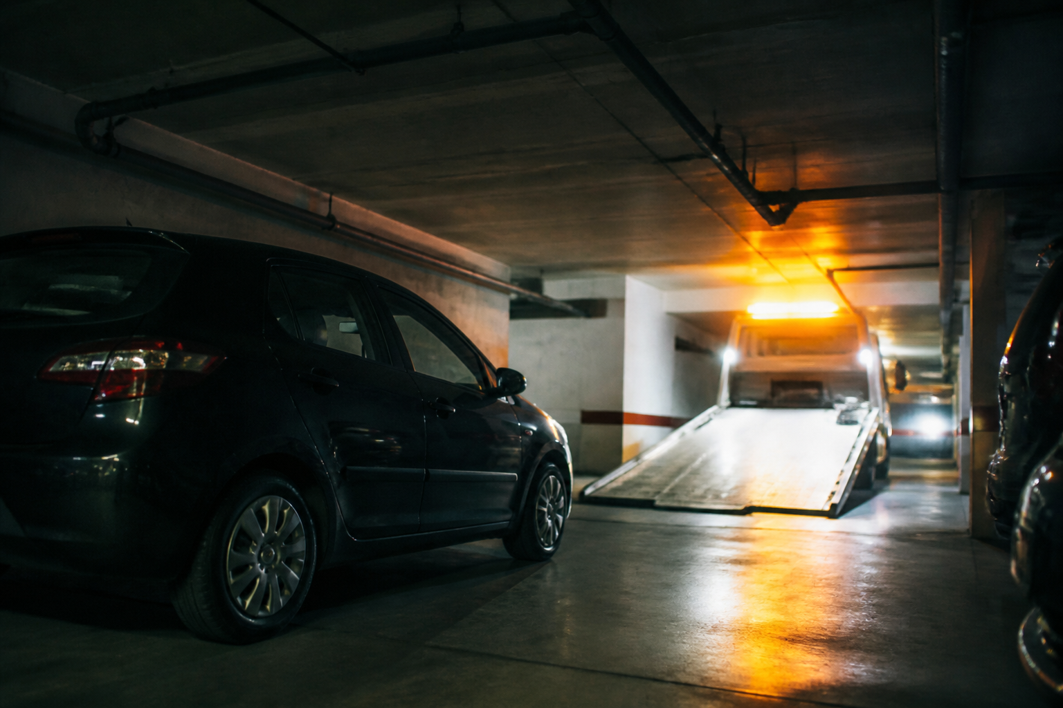 Voiture immobilisée dans parking souterrain à Paris avec dépanneuse