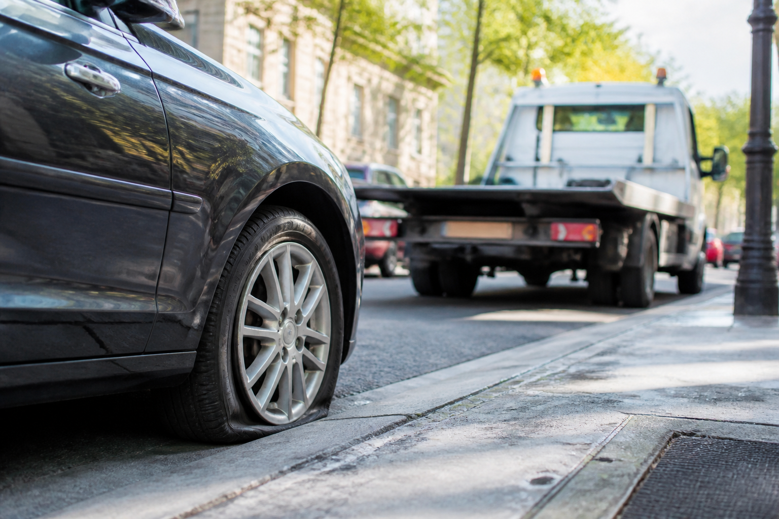 Véhicule avec pneu crevé pris en charge par dépanneuse à Paris