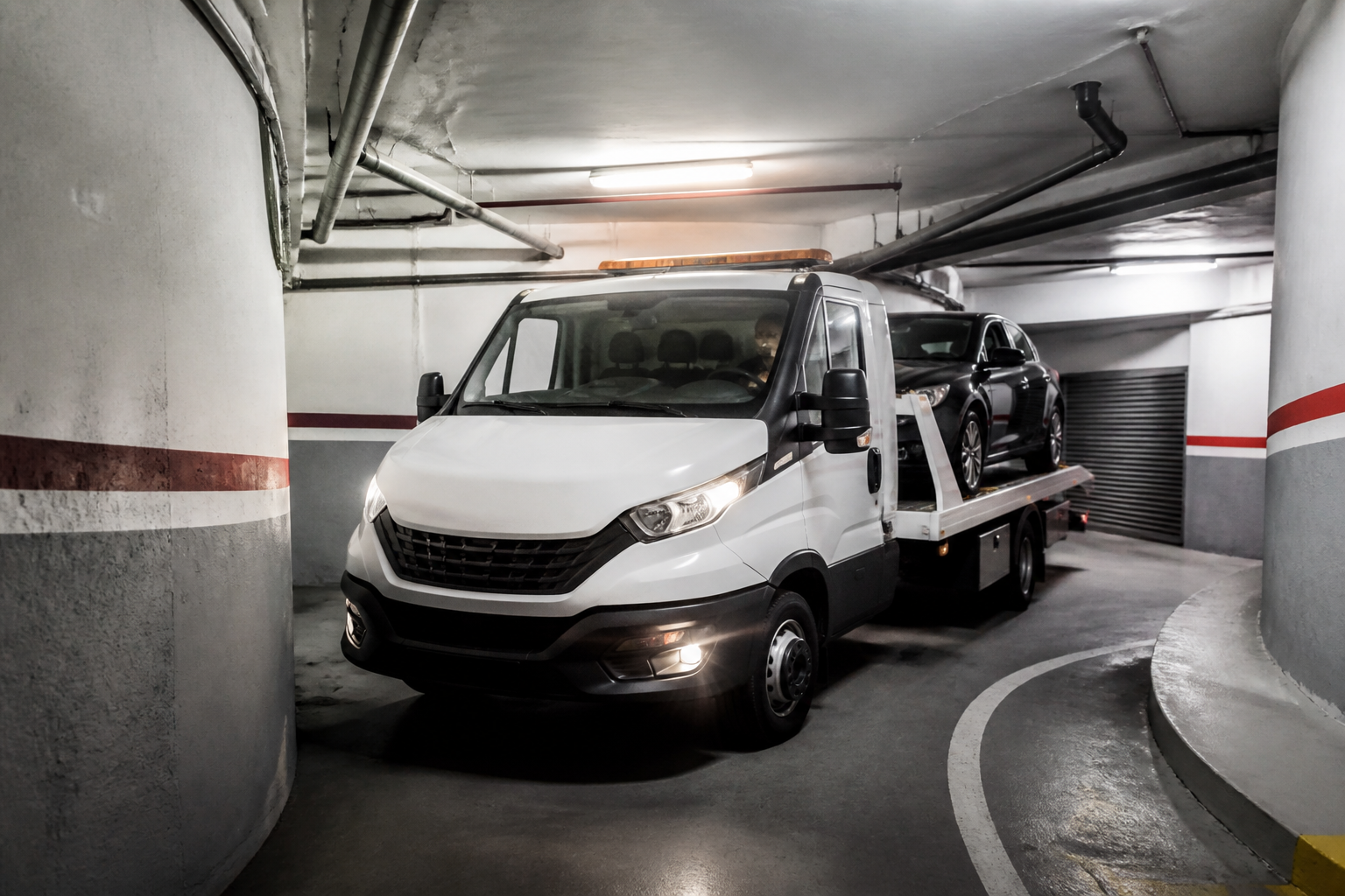 Dépanneuse manoeuvrant dans un parking souterrain parisien étroit